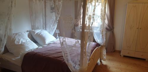 a bedroom with a bed with mosquito netting at Ferienwohnung im Landhausstiel in Winkel