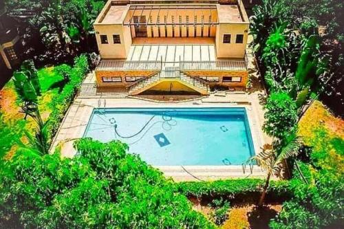 Cette chambre offre une vue sur une maison dotée d'une piscine. dans l'établissement Lux Suites Green City Gardens Syokimau, à Nairobi
