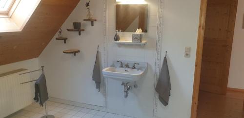 a white bathroom with a sink and a mirror at Ferienwohnung im Landhausstiel in Winkel