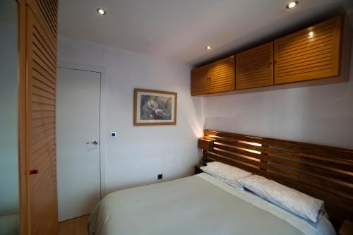 a bedroom with a bed and a wooden headboard at Apartamento Granados in Granada