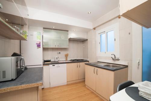 a kitchen with white cabinets and a stainless steel appliance at Apartamento Granados in Granada