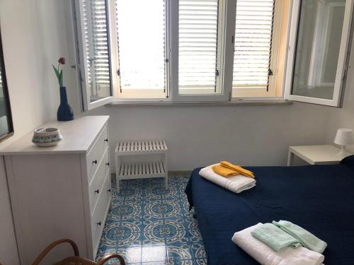 a bedroom with a blue bed and two windows at Villa Panoramica in Valderice