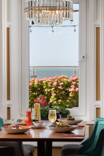 a dining room table with plates of food and a window at The Beaches Hotel and Spa in Prestatyn