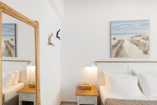 a bedroom with two beds and a mirror at Parosquare Central Suites in Parikia