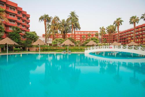 une grande piscine en face d'un hôtel dans l'établissement Pyramisa Hotel Luxor, à Louxor