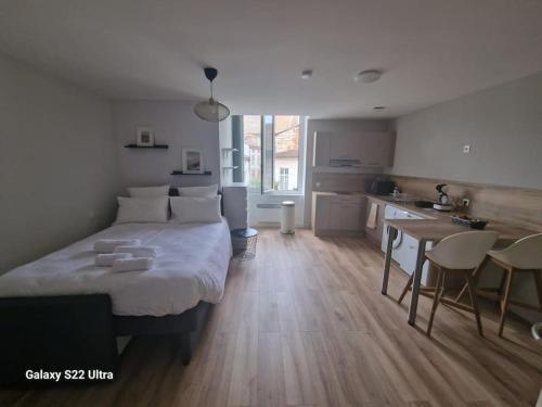 a bedroom with a large bed and a kitchen at WelcomeAgen*Wifi Fibre*Suite Sergueï Rachmaninov in Agen
