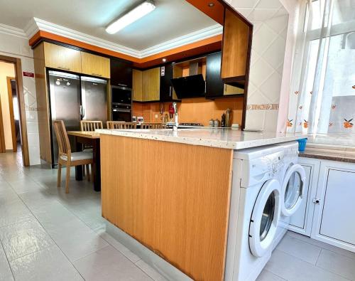eine Küche mit Waschmaschine und Trockner im Zimmer in der Unterkunft Casa Cabo Avelar T4 - Mer in Peniche