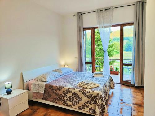 a bedroom with a bed and a large window at Affittacamere Sanja in San Ginesio
