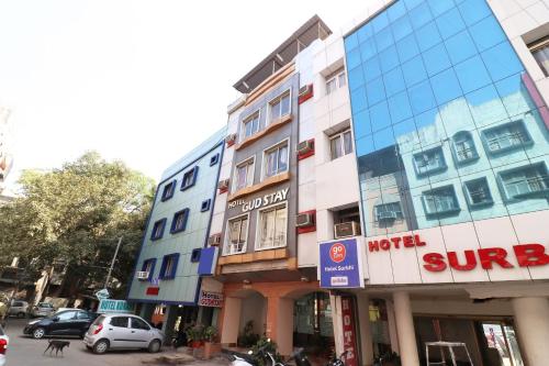 un edificio en una calle con coches aparcados delante en Hotel Gud Stay, en Bhopal