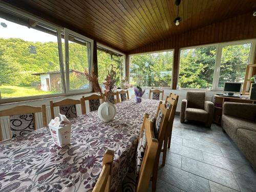 a dining room with a table and chairs and windows at Cristian in Dejani