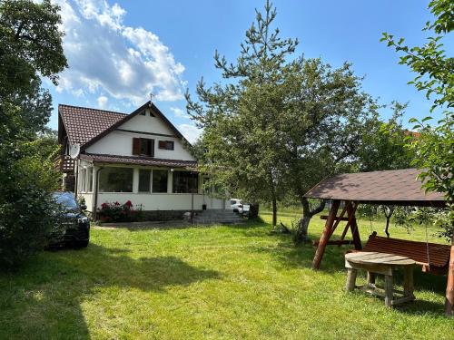 a white house with a picnic table in the yard at Cristian in Dejani