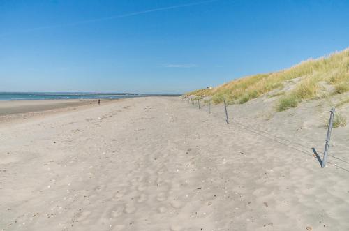 a fence on a sandy beach near the ocean at East Walls Apartment in Chichester