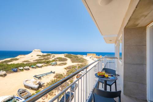 a balcony with a view of the beach and the ocean at Salini Suites in Żebbuġ