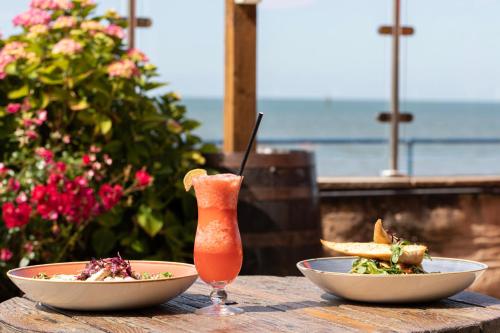 a table with two bowls of food and a drink at The Beaches Hotel and Spa in Prestatyn