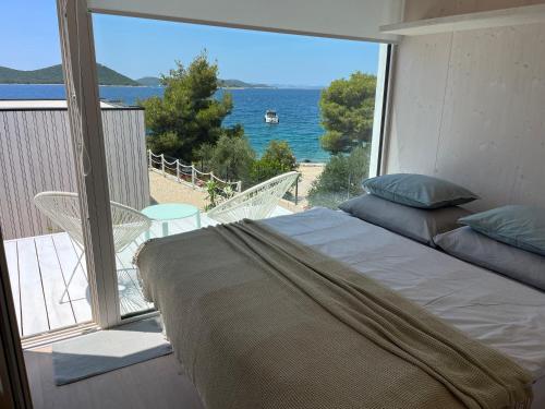 a bedroom with a bed and a view of the ocean at BUQEZ ECO RESORT - Beach Villas 2 and 8 - Seaview, new wifi! in Drage