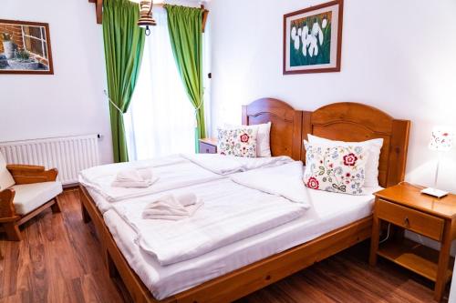 スフントゥ・ゲオルゲにある5.Evszakのベッドルーム(白い大型ベッド1台、木製ヘッドボード付)