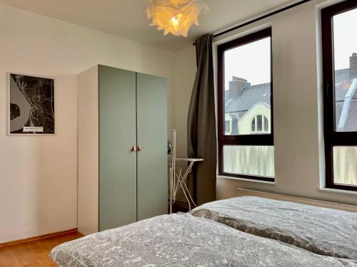 a bedroom with a bed and a large window at Bötchen - modern, zentral, für TreppensteigerInnen in Bremerhaven