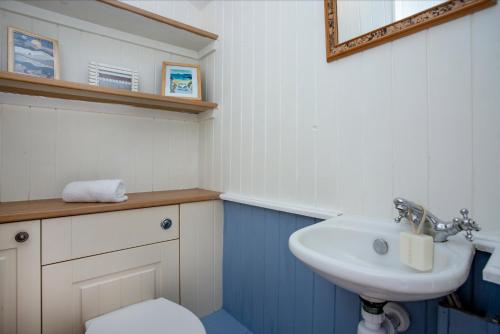 a bathroom with a white sink and a toilet at Budleigh Burrow in Budleigh Salterton