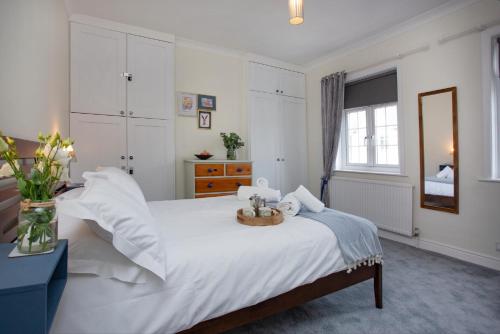 Un dormitorio con una gran cama blanca y una bandeja. en Budleigh Burrow en Budleigh Salterton