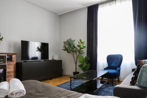ein Wohnzimmer mit einem Sofa und einem TV in der Unterkunft Modern Apartment, 3 min to "U3 Neubaugasse" in Wien