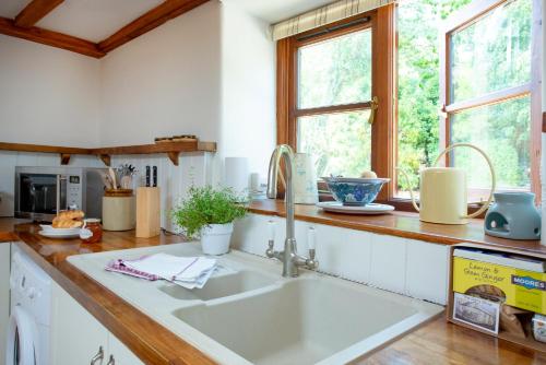 a kitchen with a sink and a window at Whitley Farm Dairy in Northleigh