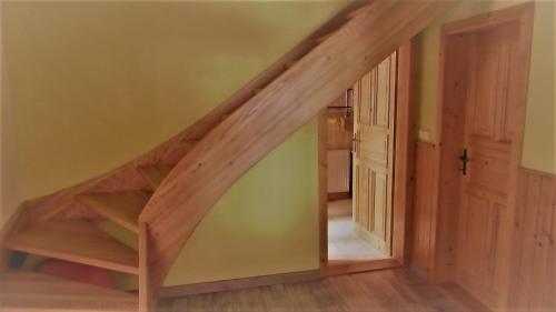 a wooden staircase in a room with a wooden door at Chata u hajného in Jindřichov