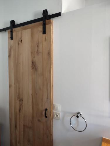 a wooden door in a white wall with a lamp at Vakantieverblijf Hof Ter Lucht in Petegem