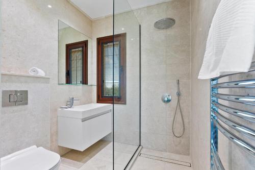 a bathroom with a shower and a toilet and a sink at 5 bedroom Villa Poseidon with private pool, Aphrodite Hills Resort in Kouklia