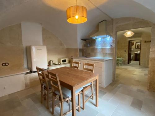 a kitchen with a wooden table and some chairs at Casa di Pietra in Crispiano