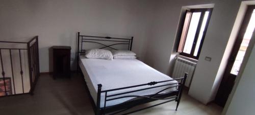 una camera da letto con letto, lenzuola e cuscini bianchi di casa vacanza caffe' a Roccavaldina