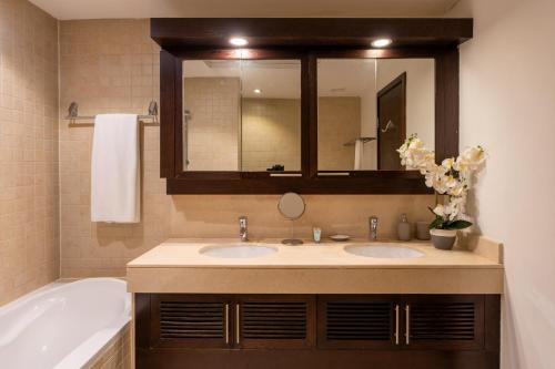 a bathroom with two sinks and a tub and a mirror at INA Homes-Tower 5 Perfect Burj Khalifa and Fountain Views in Dubai