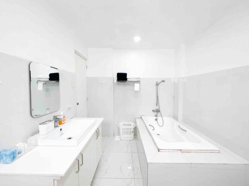 a white bathroom with two sinks and a mirror at Elegantly Presented Spacious 3 Bedroom House in San Isidro