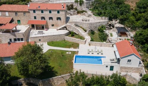 an aerial view of a house with a wall and a pool at Villa Konavoski Miri in Gruda