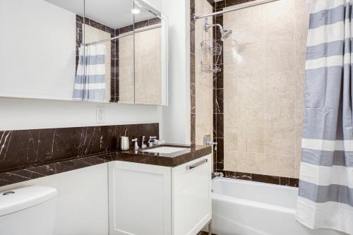 a white bathroom with a sink and a shower at Back Bay Studio w Gym nr Newbury St BOS-458 in Boston