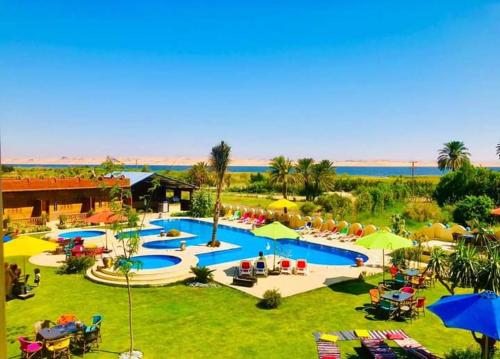 an aerial view of a swimming pool with umbrellas at Tunis Pyramids Hotel - فندق اهرامات تونس in Tunis