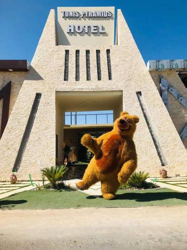 a large teddy bear standing in front of a hotel at Tunis Pyramids Hotel - فندق اهرامات تونس in Tunis