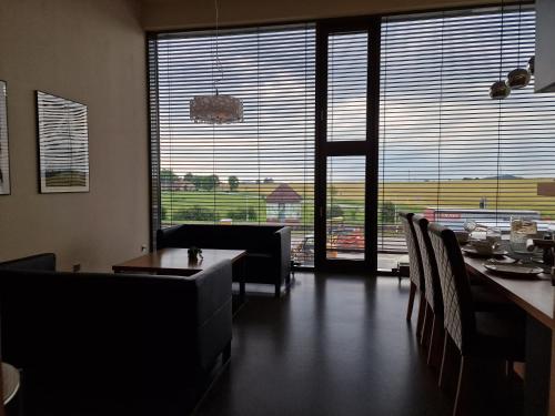 a dining room with a table and chairs and large windows at Hollywood Dream in Knínice u Boskovic