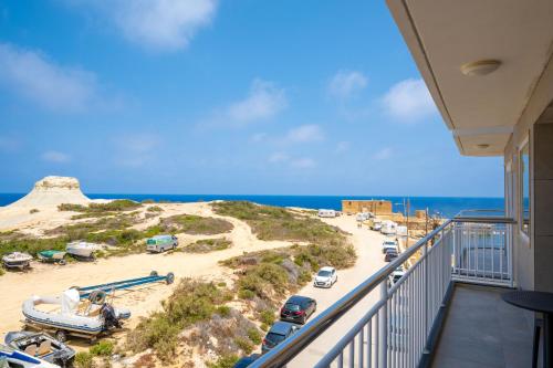a balcony with a view of a beach and the ocean at Salini Suites in Żebbuġ