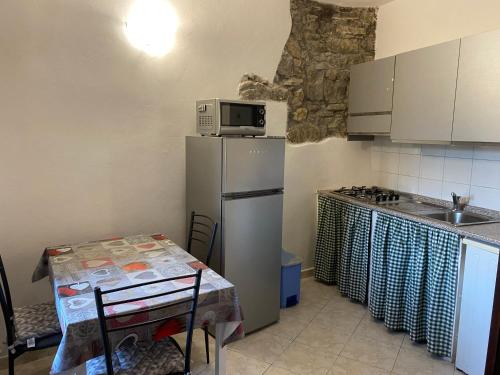a kitchen with a refrigerator and a table and a microwave at Casa di Filippo in Arcola
