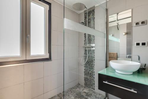 une salle de bain avec un lavabo et une douche en verre dans l'établissement T4 82m2 - Idéal location moyenne durée, 3 chambres, parking, coucher de soleil, à Montpellier