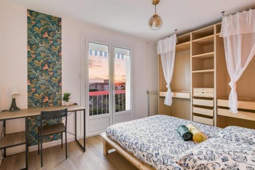 une chambre avec un lit, un bureau et une fenêtre dans l'établissement T4 82m2 - Idéal location moyenne durée, 3 chambres, parking, coucher de soleil, à Montpellier