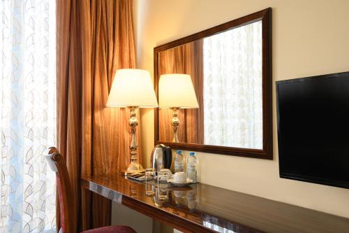 a hotel room with two lamps and a mirror at Royal Plaza by Stellar Hotels, Yerevan in Yerevan