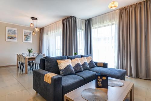 a living room with a blue couch and a table at Baltic Park Plaza by Baltic Home in Świnoujście