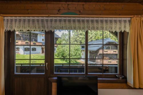 a window with a view of a house at Hapimag Ferienwohnungen Sonnleitn in Sonnenalpe Nassfeld