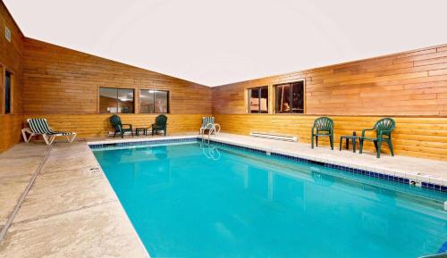 a swimming pool in a house with chairs around it at Super 8 by Wyndham Ashland in Ashland