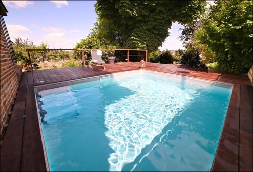 a swimming pool with blue water in a backyard at Honfleur, Entre Terre & Estuaire in La Rivière Saint Sauveur