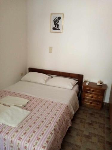um pequeno quarto com uma cama e uma mesa de cabeceira em Spilios House em Apollon