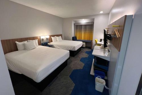 シャーロットにあるMicrotel Inn & Suites by Wyndham Charlotte/Northlakeのベッド2台とテレビが備わるホテルルームです。