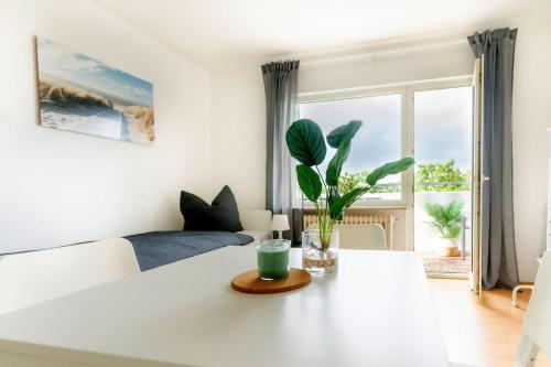a living room with a white table with a plant on it at Nice Apartment with balcony in Linden in Linden