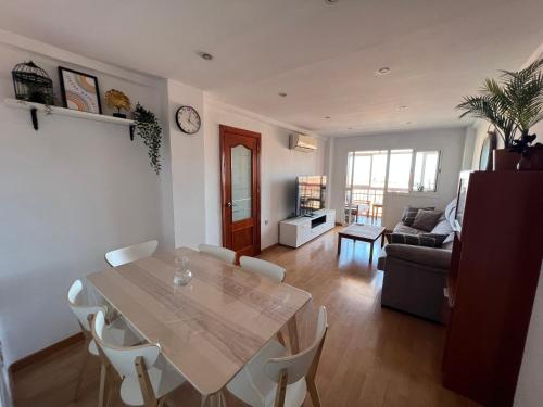 een woonkamer met een tafel en een bank bij 3 Bedrooms Apt WITH THE SEA VIEW in Málaga